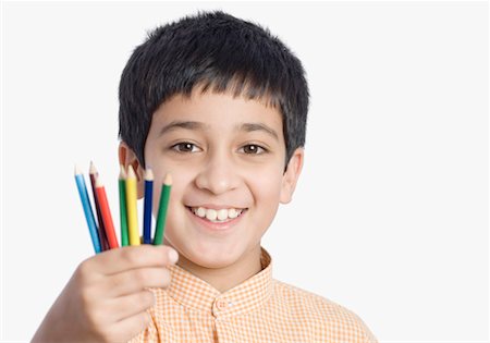 preteen boy happy white background - Portrait of a boy holding colored pencils Stock Photo - Premium Royalty-Free, Code: 630-01491721