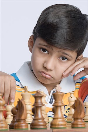 peça perdida - Portrait of a boy playing chess Foto de stock - Royalty Free Premium, Número: 630-01491730