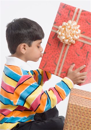 Profil de côté d'un garçon tenant et embrasser un cadeau Photographie de stock - Premium Libres de Droits, Code: 630-01491804