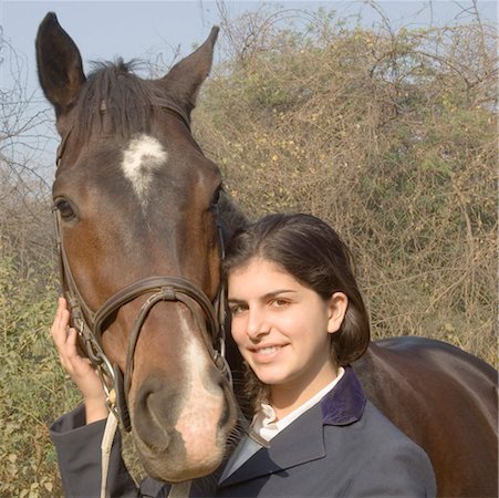 riding outfit - Portrait d'une jeune adolescente debout avec un cheval et souriant Photographie de stock - Premium Libres de Droits, Code: 630-01491835