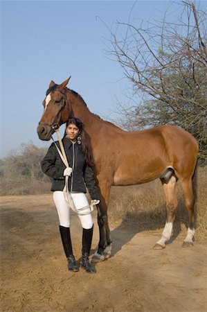 riding outfit - Portrait d'une jeune femme debout avec un cheval Photographie de stock - Premium Libres de Droits, Code: 630-01491832