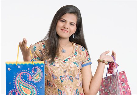 Portrait of a teenage girl holding shopping bags and smirking Stock Photo - Premium Royalty-Free, Code: 630-01491977