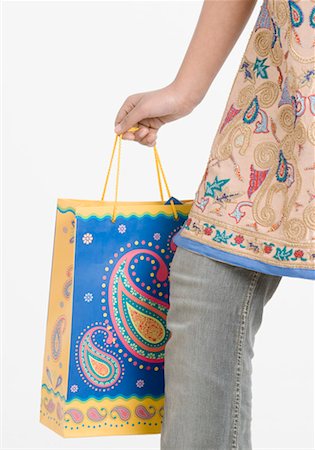 Low section view of a teenage girl holding a shopping bag Stock Photo - Premium Royalty-Free, Code: 630-01491978