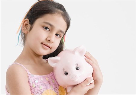 Portrait of a girl holding a piggy bank Stock Photo - Premium Royalty-Free, Code: 630-01492099