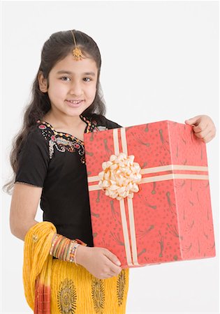 Portrait of a girl in traditional clothing holding a gift Stock Photo - Premium Royalty-Free, Code: 630-01492092
