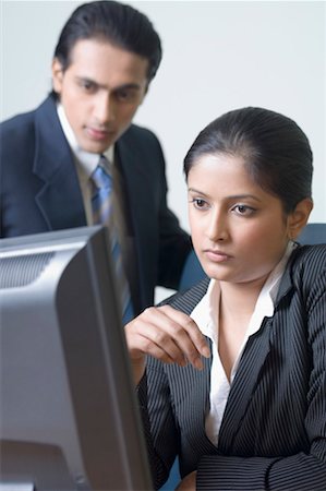 Businesswoman and a businessman looking at a computer Stock Photo - Premium Royalty-Free, Code: 630-01492143