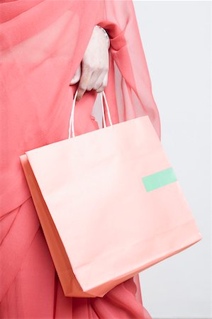 Mid section view of a woman holding a shopping bag Stock Photo - Premium Royalty-Free, Code: 630-01492167