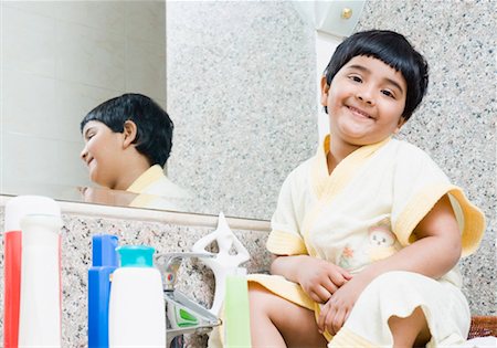 Portrait of a girl sitting in front of a bathroom mirror Stock Photo - Premium Royalty-Free, Code: 630-01492182