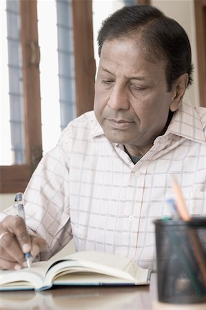 schreibtischablage - Close-up of a mature man writing in a diary Foto de stock - Sin royalties Premium, Código: 630-01492217