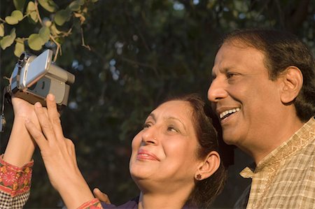 Close-up of a mature woman holding a video camera with a mature man smiling beside her Stock Photo - Premium Royalty-Free, Code: 630-01492236