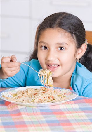 espanador de penas - Portrait of a girl eating spaghetti with a fork Foto de stock - Royalty Free Premium, Número: 630-01492409