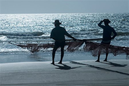 simsearch:630-01492485,k - Silhouette of two men holding a fishing net on the beach, Morjim Beach, Goa, India Stock Photo - Premium Royalty-Free, Code: 630-01492487