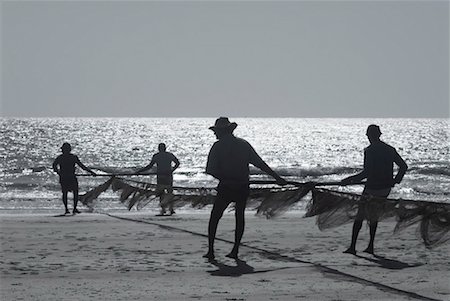 simsearch:630-01492485,k - Silhouette of four men holding a fishing net on the beach, Morjim Beach, Goa, India Stock Photo - Premium Royalty-Free, Code: 630-01492488