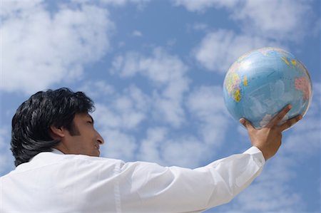 Rear view of a businessman holding a globe Stock Photo - Premium Royalty-Free, Code: 630-01492508