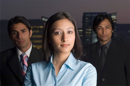 Portrait of a businesswoman with two businessmen standing behind her Stock Photo - Premium Royalty-Free, Code: 630-01492577