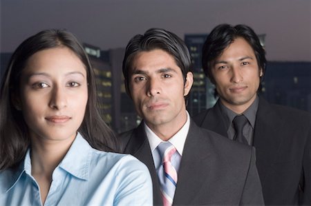 simsearch:630-01076251,k - Portrait of a businesswoman standing with two businessmen behind her Stock Photo - Premium Royalty-Free, Code: 630-01492578