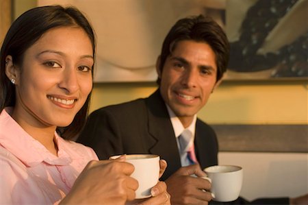 simsearch:630-01492693,k - Portrait d'un homme et une femme tenant des tasses à café et souriant Photographie de stock - Premium Libres de Droits, Code: 630-01492571