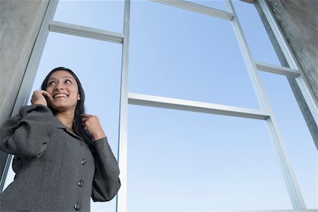 Low angle view of a businesswoman talking on a mobile phone Stock Photo - Premium Royalty-Free, Code: 630-01492592