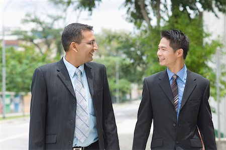 Two businessmen looking at each other and smiling Stock Photo - Premium Royalty-Free, Code: 630-01492667