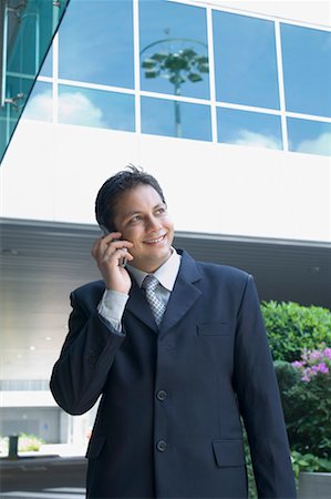 simsearch:630-01873878,k - Homme d'affaires parlant sur un téléphone mobile et souriant Photographie de stock - Premium Libres de Droits, Code: 630-01492820