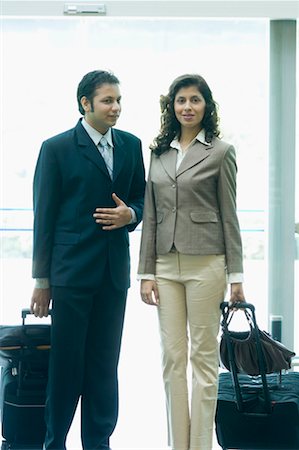 simsearch:630-01492837,k - Businessman and a businesswoman standing with their luggage Stock Photo - Premium Royalty-Free, Code: 630-01492843