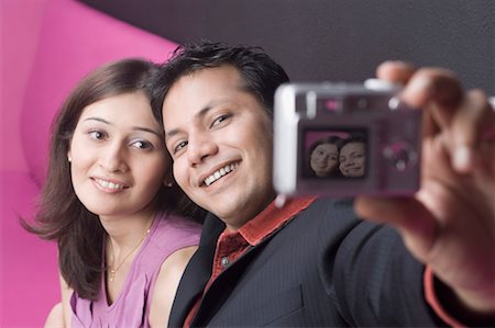 Young couple taking a photograph of themselves Stock Photo - Premium Royalty-Free, Code: 630-01492924