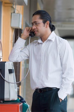 Mid adult man talking on a pay phone Stock Photo - Premium Royalty-Free, Code: 630-01492954