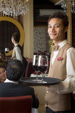 simsearch:630-01707979,k - Portrait of a waiter holding wine glasses in a tray Stock Photo - Premium Royalty-Free, Code: 630-01492968