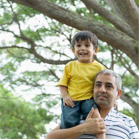 father son shoulder indian - Mid adult man carrying his son on his shoulders Stock Photo - Premium Royalty-Free, Code: 630-01492996