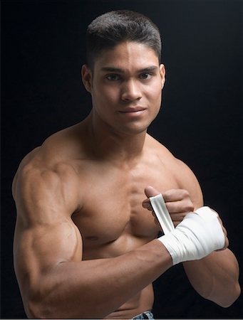 Portrait of a young man bandaging his hand Fotografie stock - Premium Royalty-Free, Codice: 630-01493087