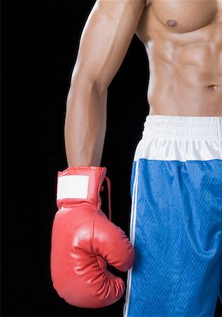 Mid section view of a boxer wearing a boxing glove Stock Photo - Premium Royalty-Free, Code: 630-01493094