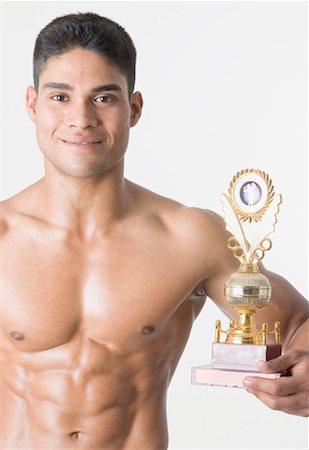 ethnic bodybuilding - Portrait of a young man holding a trophy Stock Photo - Premium Royalty-Free, Code: 630-01493106