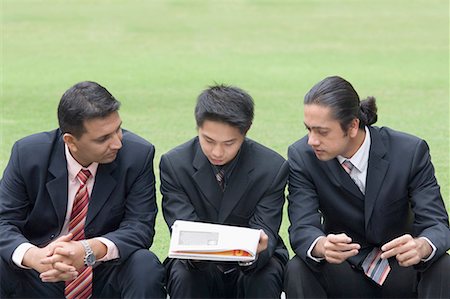 Three businessmen reading a document Stock Photo - Premium Royalty-Free, Code: 630-01707779