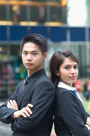 Portrait of a businessman and a businesswoman standing back to back with their arms crossed Stock Photo - Premium Royalty-Free, Code: 630-01707789