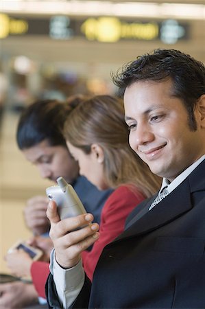 simsearch:630-01873262,k - Close-up of a businessman holding a mobile phone and smiling Stock Photo - Premium Royalty-Free, Code: 630-01707853