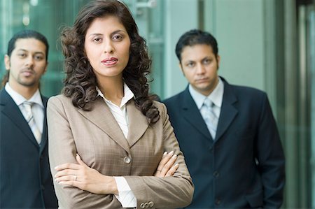 portrait and woman and closeup and arms - Portrait of a businesswoman with two businessmen standing behind her Stock Photo - Premium Royalty-Free, Code: 630-01707878