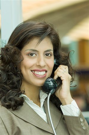 simsearch:630-01492693,k - Portrait d'une femme d'affaires parlant sur un téléphone public Photographie de stock - Premium Libres de Droits, Code: 630-01707872