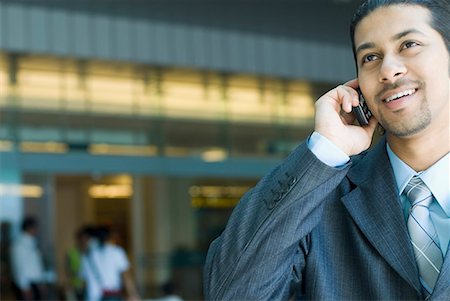 Close-up of a businessman talking on a mobile phone and smiling Stock Photo - Premium Royalty-Free, Code: 630-01707922