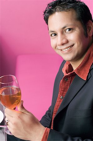 simsearch:630-01872567,k - Portrait d'un jeune homme tenant un verre de vin et souriant Photographie de stock - Premium Libres de Droits, Code: 630-01707932