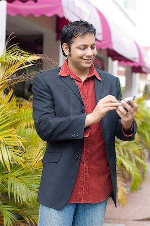 simsearch:630-01708665,k - Businessman using a palmtop and smiling Stock Photo - Premium Royalty-Free, Code: 630-01707943