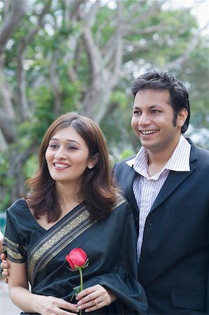 poses in saree for outdoor photography - Young woman holding a rose and smiling with a young man Foto de stock - Sin royalties Premium, Código: 630-01707966