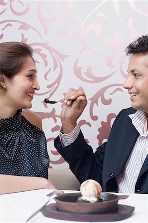feeding each other with spoons - Young man feeding an ice-cream to a young woman Stock Photo - Premium Royalty-Free, Code: 630-01707994