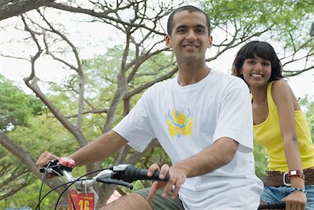 simsearch:630-01708059,k - Portrait of a young couple riding a bicycle and smiling Stock Photo - Premium Royalty-Free, Code: 630-01708003