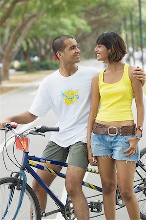Young couple standing with a bicycle and smiling Stock Photo - Premium Royalty-Free, Code: 630-01708020