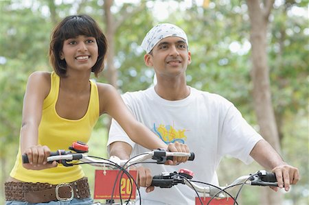 simsearch:630-01708059,k - Close-up of a young couple sitting on bicycles and smiling Stock Photo - Premium Royalty-Free, Code: 630-01708048