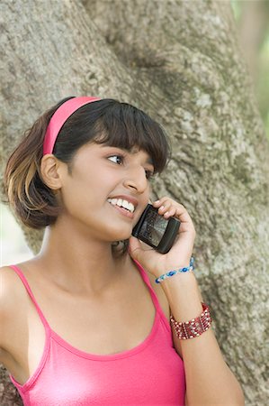 simsearch:640-03260389,k - Close-up of a young woman talking on a mobile phone and smiling Stock Photo - Premium Royalty-Free, Code: 630-01708079