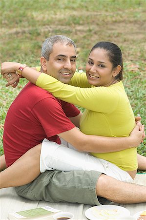 Portrait of a mid adult couple sitting in a park and embracing each other Stock Photo - Premium Royalty-Free, Code: 630-01708105