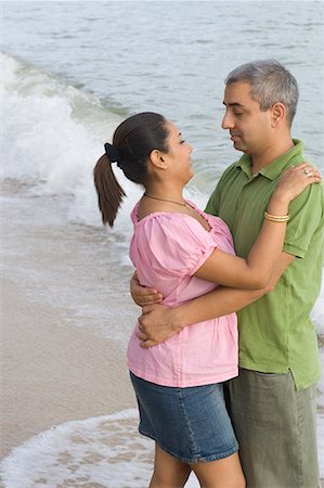 Side profile of a mid adult couple embracing each other on the beach Stock Photo - Premium Royalty-Free, Code: 630-01708148