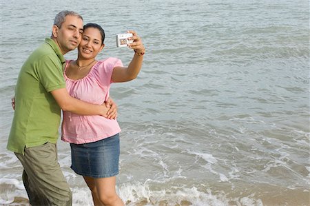 self - Mid adult couple taking a photograph of themselves on the beach Stock Photo - Premium Royalty-Free, Code: 630-01708156