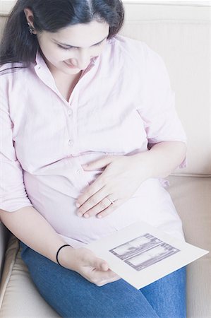 High angle view of a pregnant woman holding an ultrasound report Stock Photo - Premium Royalty-Free, Code: 630-01708210